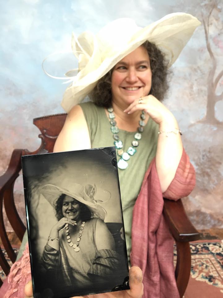 Woman dressed up with a portrait of someone wearing a similar outfit