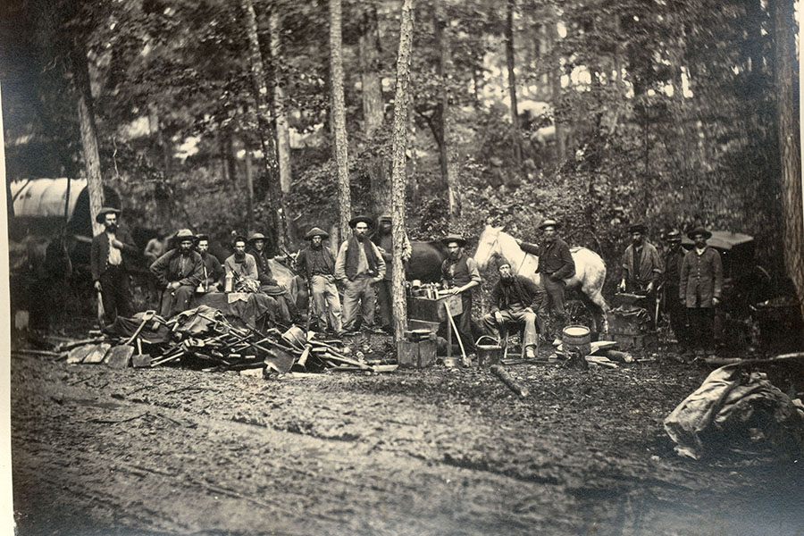 a black and white photo of a group of soldiers in the forest