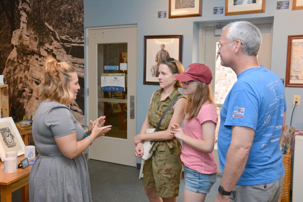 A staff member talks to guests during their employment at H.H. Bennet Studio & Museum.