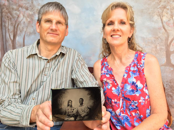 A couple (man and woman) pose for their tintypes, featured in the foreground.